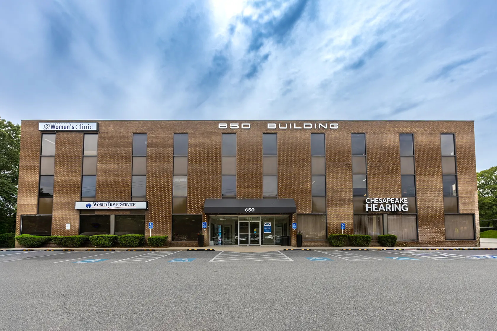 An exterior image of the 850 Building, a three-story brick office building with move in ready office spaces in Severna Park, MD.