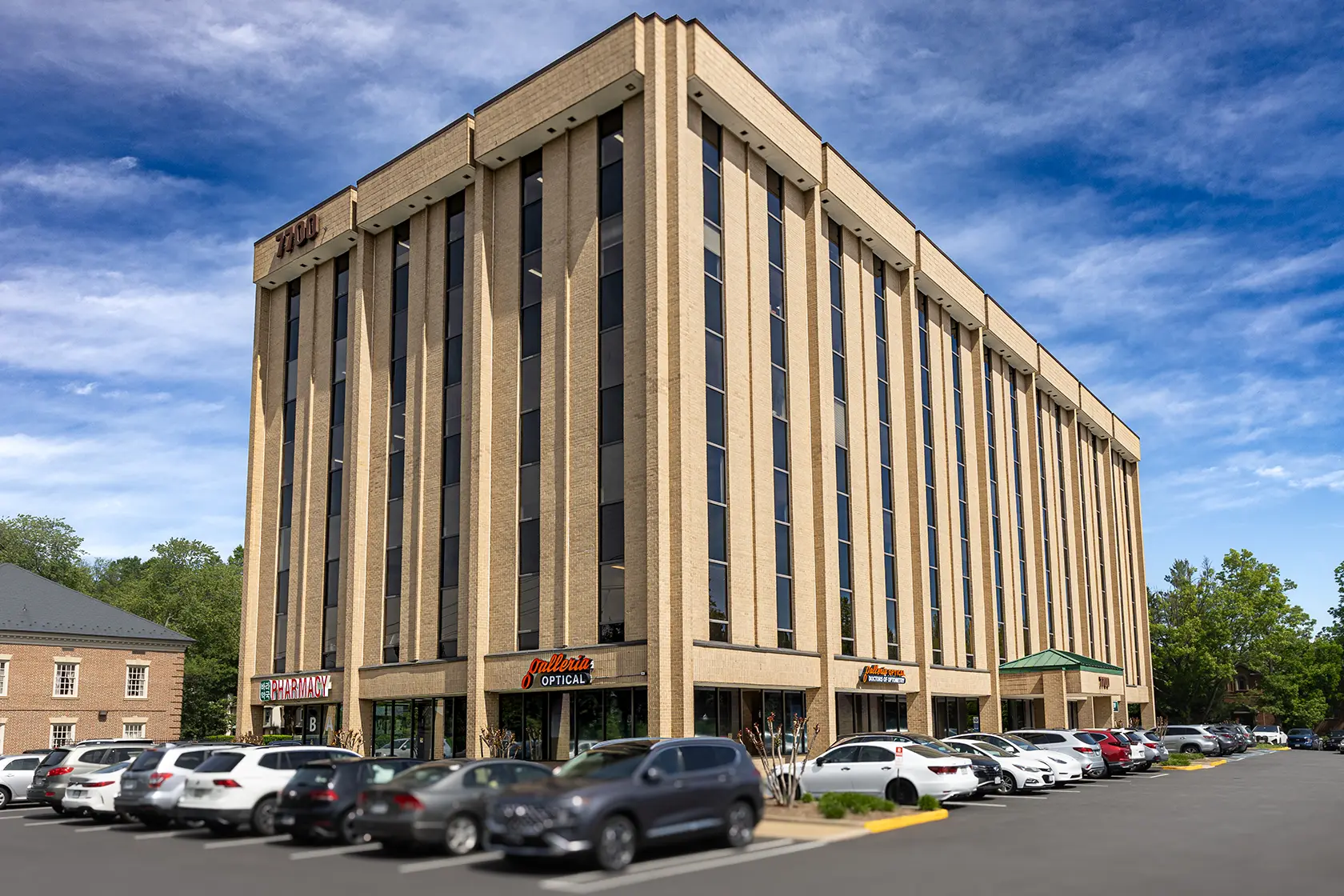 An exterior image of a six-story office building with a parking lot and turnkey office spaces for lease in Northern Virginia.