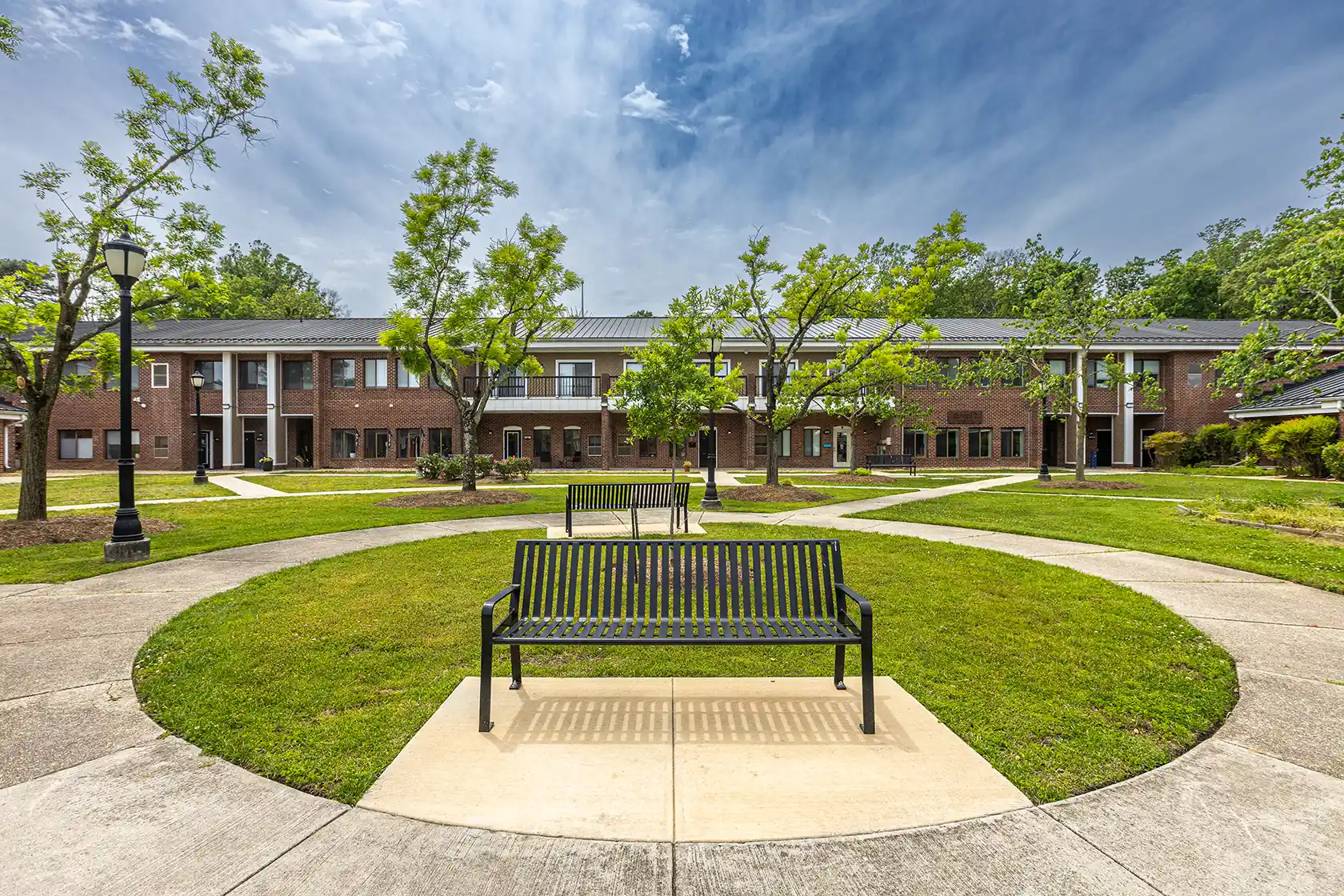 A bench and trees outside a brick commercial property with a contemporary office space for lease Severna Park MD.